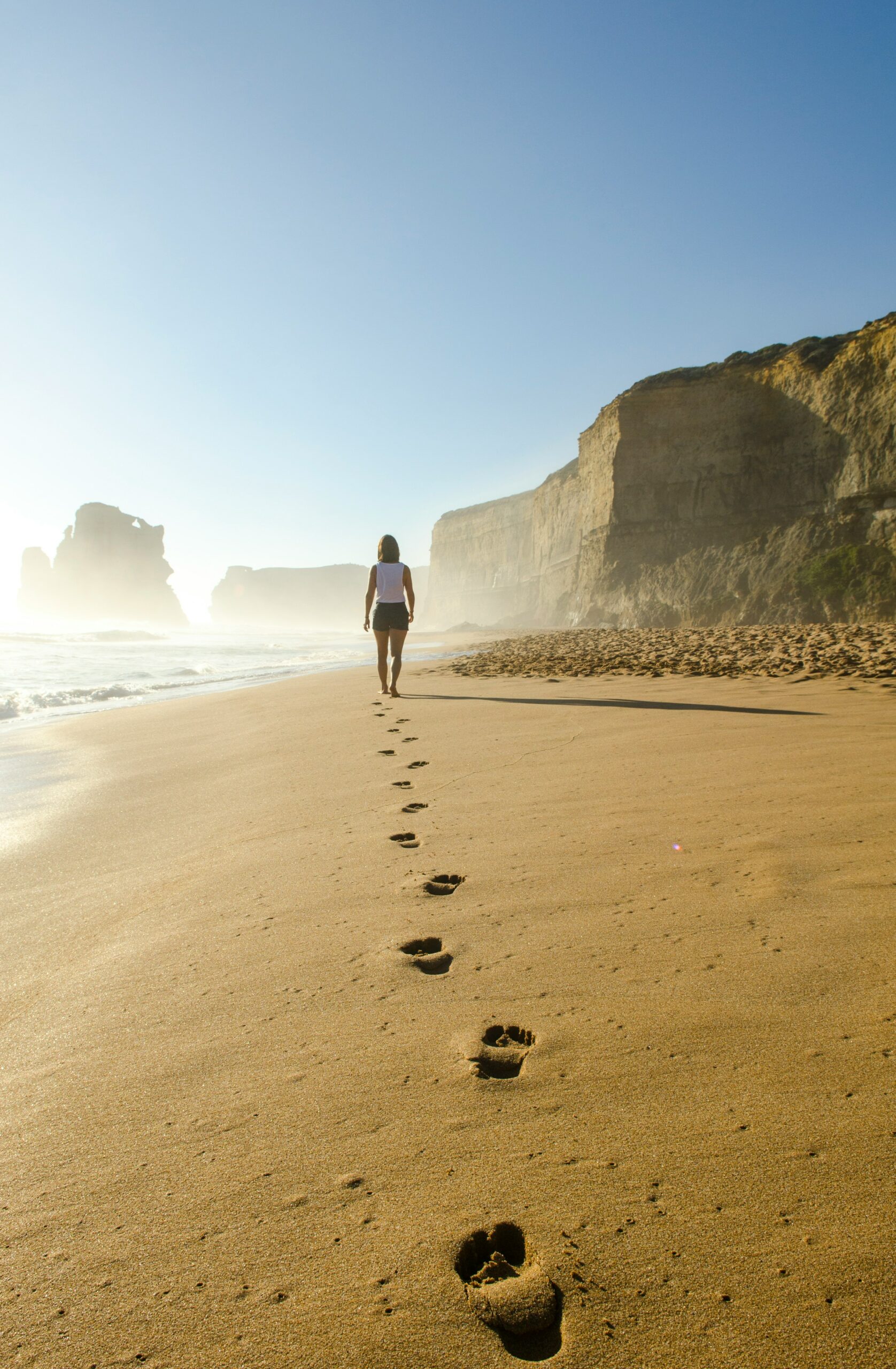 woman walking on the sand leaving footprints for quiet and meditation